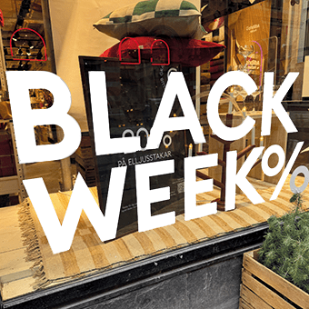 Budskapet Black Week% i vitt på ett skyltfönster.