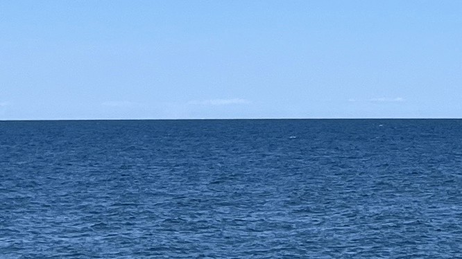 Blå himmel och blått hav nedtill.