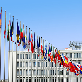 Flaggorna från olika nationaliteter som vajar mot den klarblå himlen symboliserar enhet i mångfald och ger en känsla av global gemenskap och samhörighet, där varje flagga representerar en unik kultur och historia.