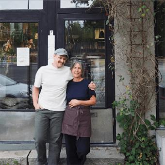 Man och kvinna framför caféet står och håller om varandra