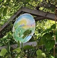 En rund tavla högst upp i gaveln av en pergola.