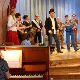 En samling människor står uppe på scenen.