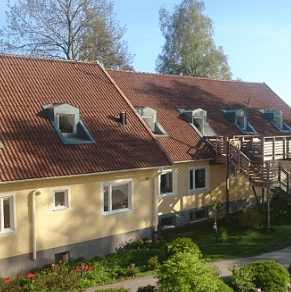 Gula radhus och prunkande trädgårdar.