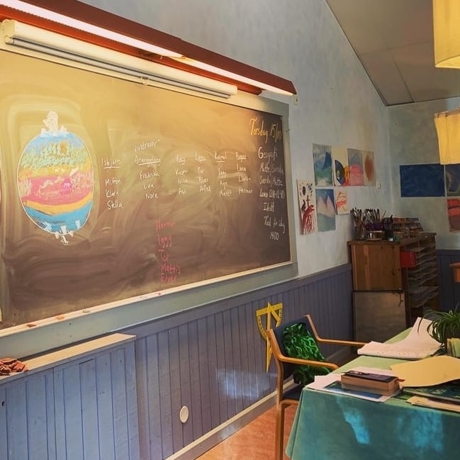 I ett klassrum syns svarta tavlan på väggen.